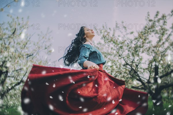 Caucasian woman dancing near flowering trees