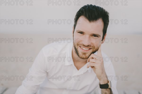 Caucasian man sitting on beach