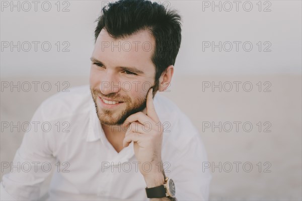 Caucasian man sitting on beach