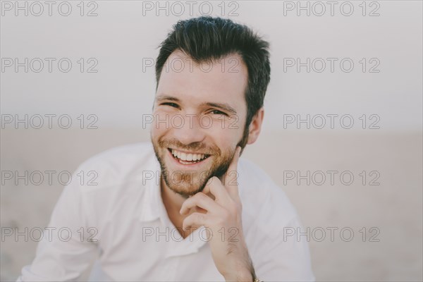 Caucasian man sitting on beach