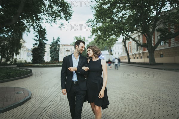 Smiling Caucasian couple walking arm in arm