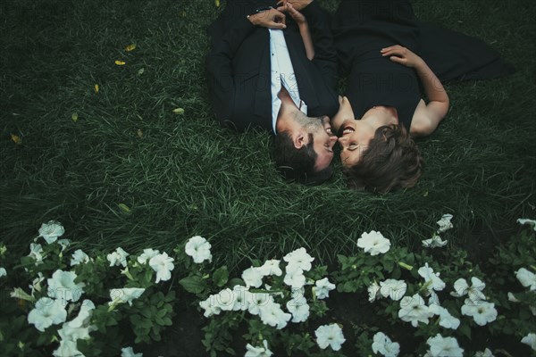Caucasian couple laying in grass laughing
