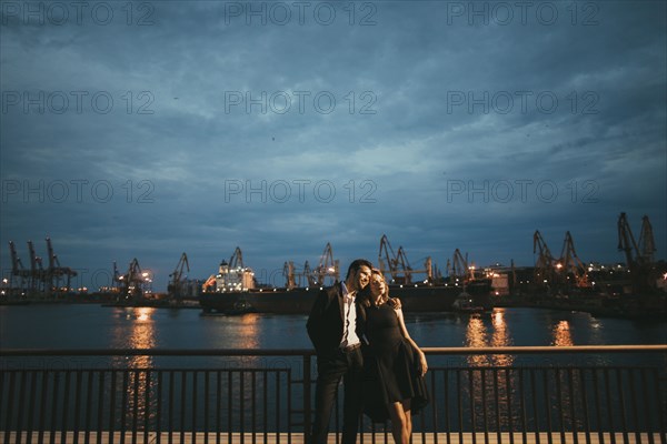 Caucasian couple hugging at waterfront