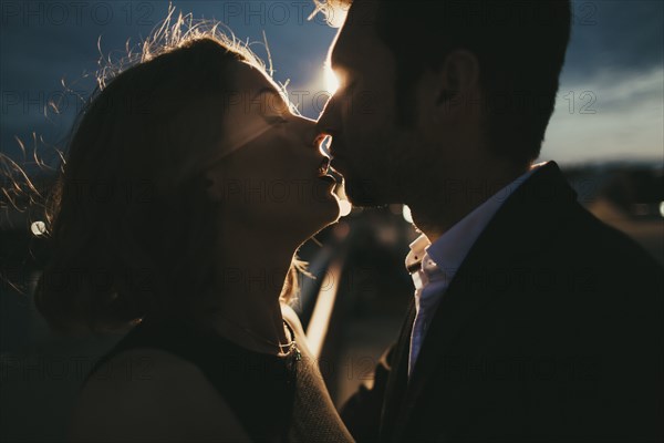 Caucasian couple kissing at night