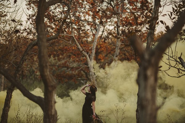 Caucasian woman standing in fog in forest