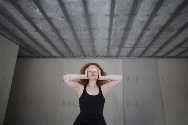 Caucasian woman covering eyes with plastic