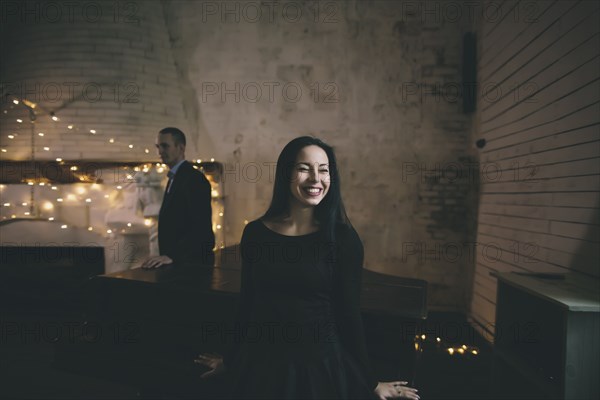 Caucasian couple leaning on piano near fireplace