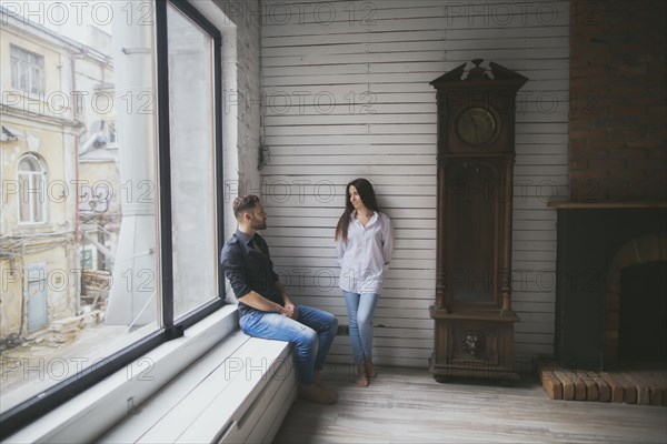 Caucasian couple hanging out near window