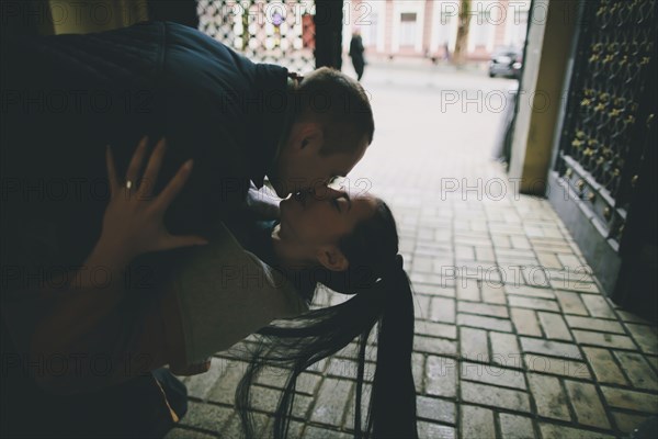 Caucasian man dipping and kissing woman