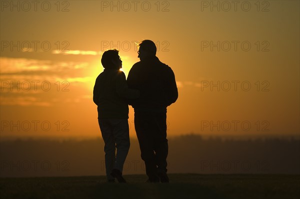 Hispanic couple standing outdoors at sunset