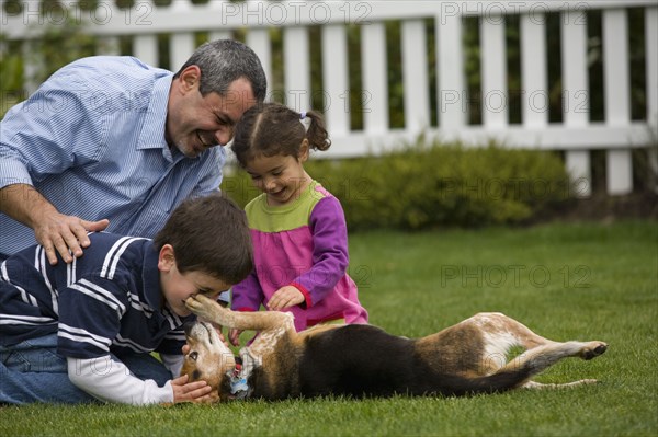 Family playing with dog in backyard