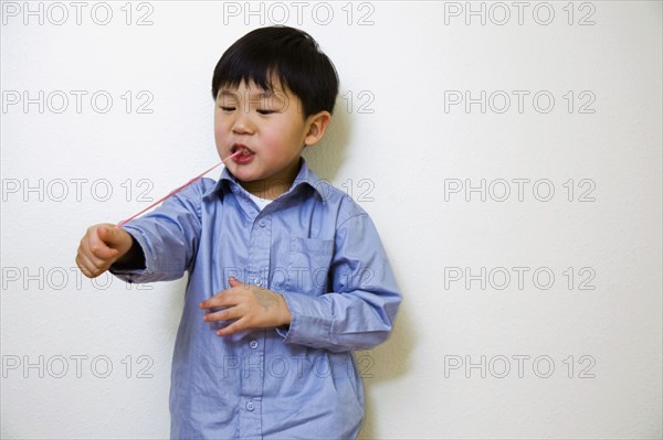 Korean boy pulling gum from mouth