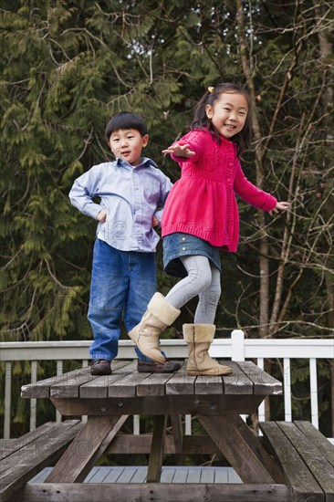 Korean children playing on picnic bench