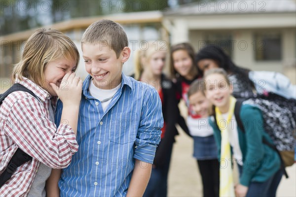 Caucasian school boys whispering together