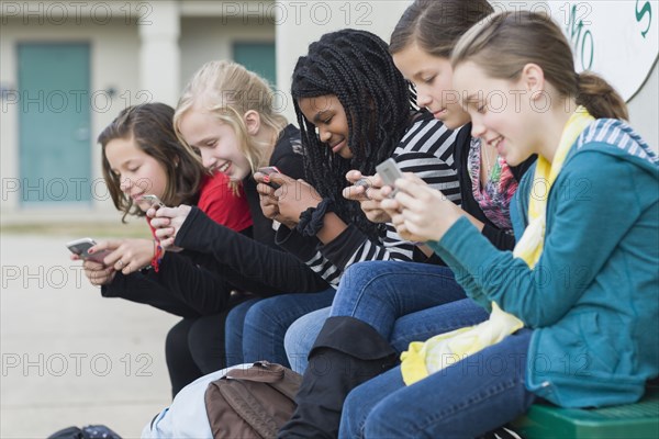 School girls text messaging on cell phones