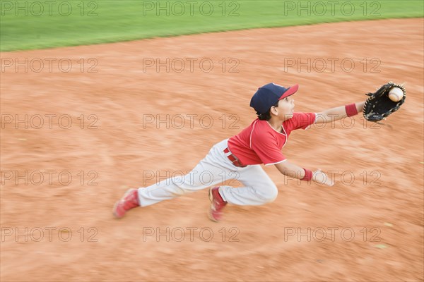 Hispanic baseball player catching ball