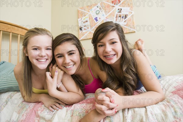 Smiling Caucasian teenage girls in bedroom