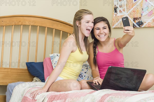 Caucasian teenage girls taking self-portrait with cell phone