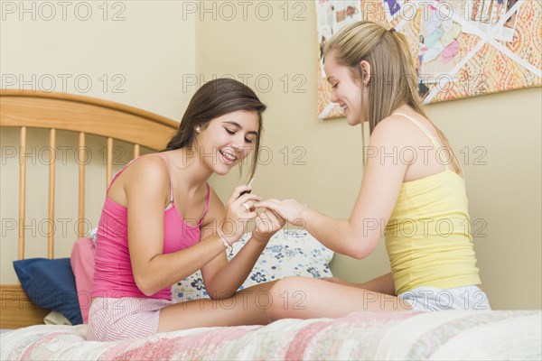 Caucasian teenage girls getting manicures