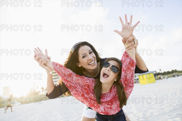 Playful Hispanic mother and daughter