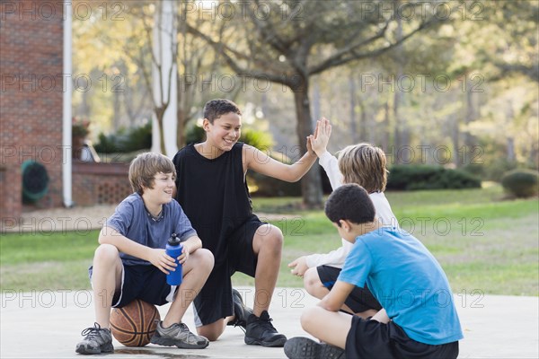 Boys sitting with basketball