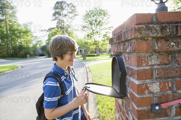 Caucasian boy opening mailbox