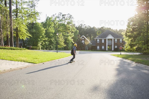 Caucasian boy skateboarding on road