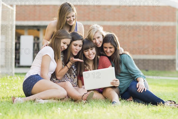 Caucasian friends looking at laptop together