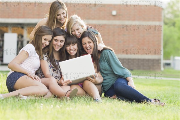 Caucasian friends looking at laptop together