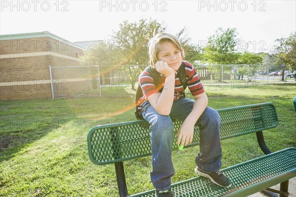 Caucasian boy sitting on bench