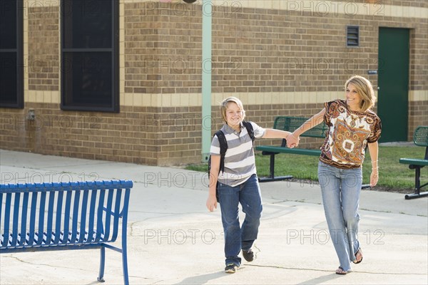 Caucasian mother and son walking and holding hands