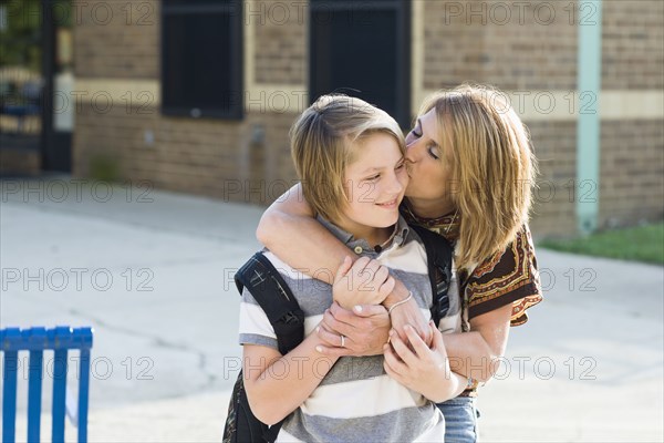 Caucasian mother kissing son