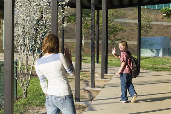 Caucasian mother waving to son