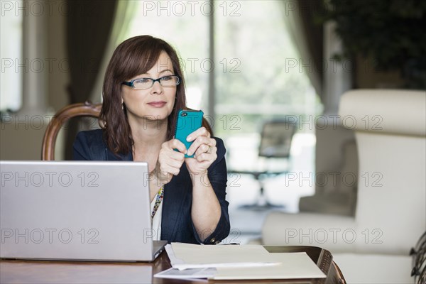 Caucasian businesswoman text messaging on cell phone