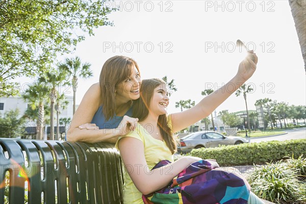 Caucasian mother and daughter taking self-portrait