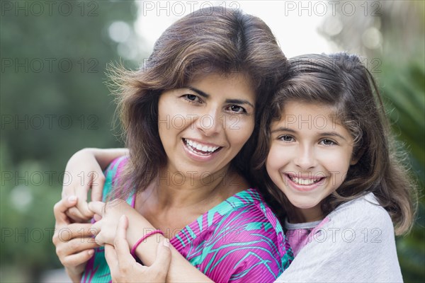 Smiling Hispanic mother and daughter