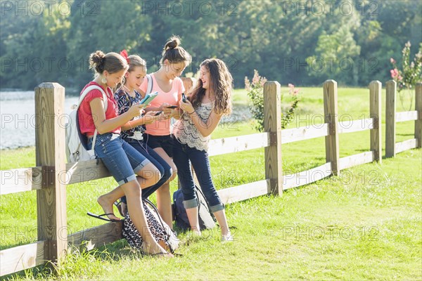 Caucasian friends hanging out using cell phones and digital tablet