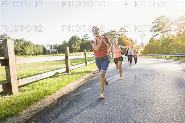 Caucasian girls running on road
