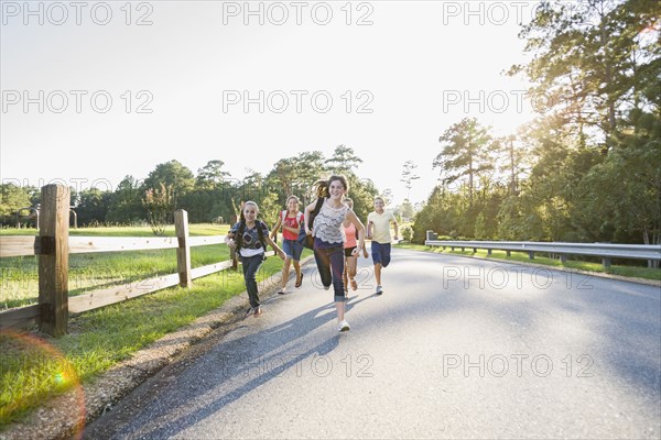 Caucasian friends running on road