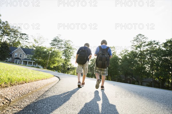 Caucasian boys walking in road