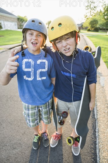 Caucasian boys standing together with skateboards