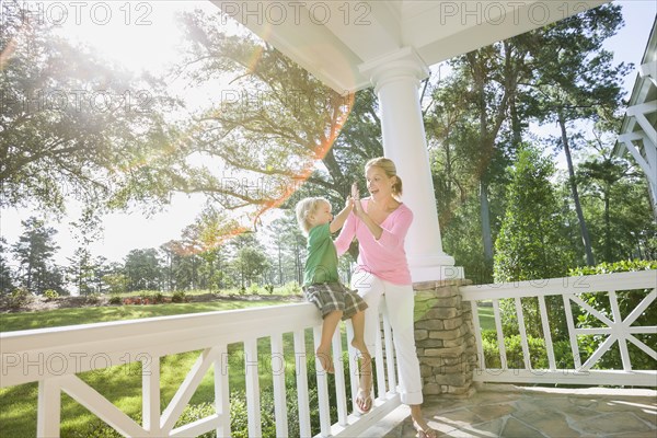 Caucasian mother and son playing on porch together