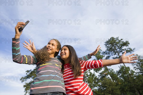 Smiling girls taking pictures outdoors