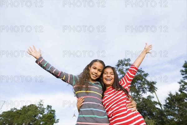 Smiling girls hugging outdoors