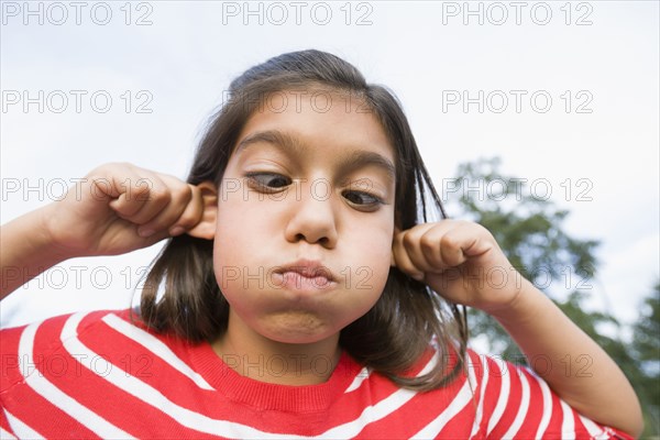 Hispanic girl making face outdoors