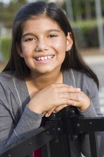 Hispanic girl leaning on metal railing