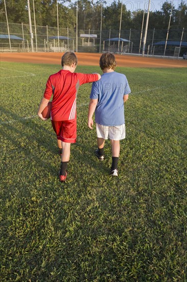 Caucasian boys walking in field