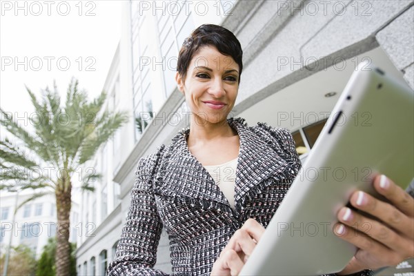 Cape Verdean businesswoman using tablet computer outdoors