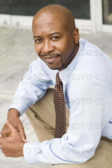 Black businessman sitting outdoors
