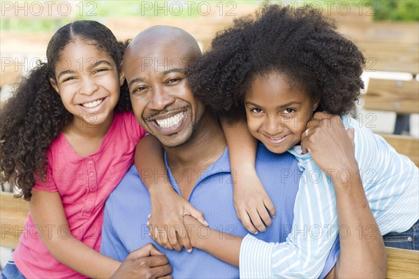 Father and daughters smiling together